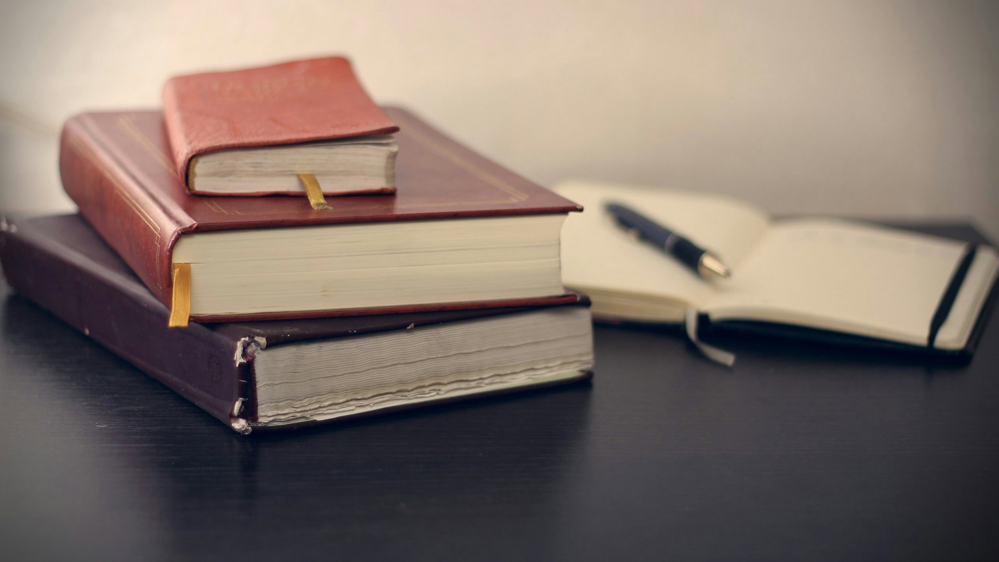selective-focus-photography-of-three-books-beside-opened-notebook.jpg selective focus photography of three books beside opened notebook