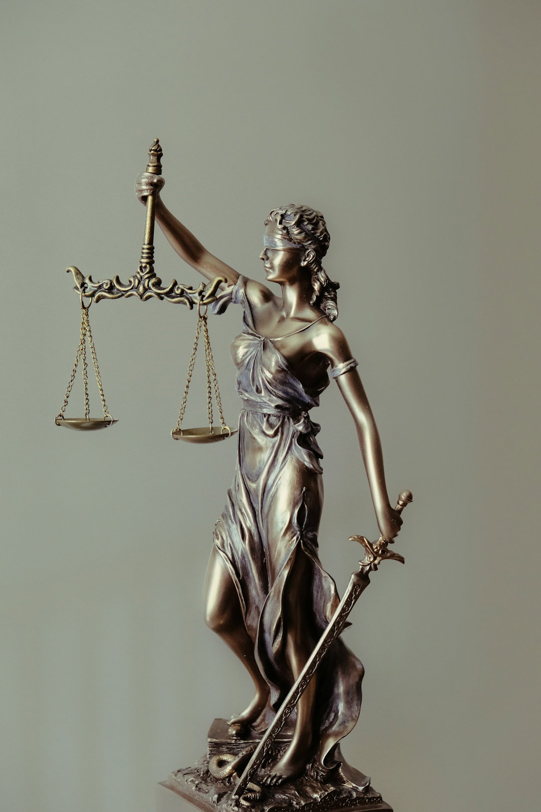 woman-in-gold-dress-holding-sword-figurine.jpg woman in gold dress holding sword figurine